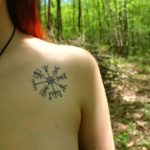 фото женская татуировка руны над грудью